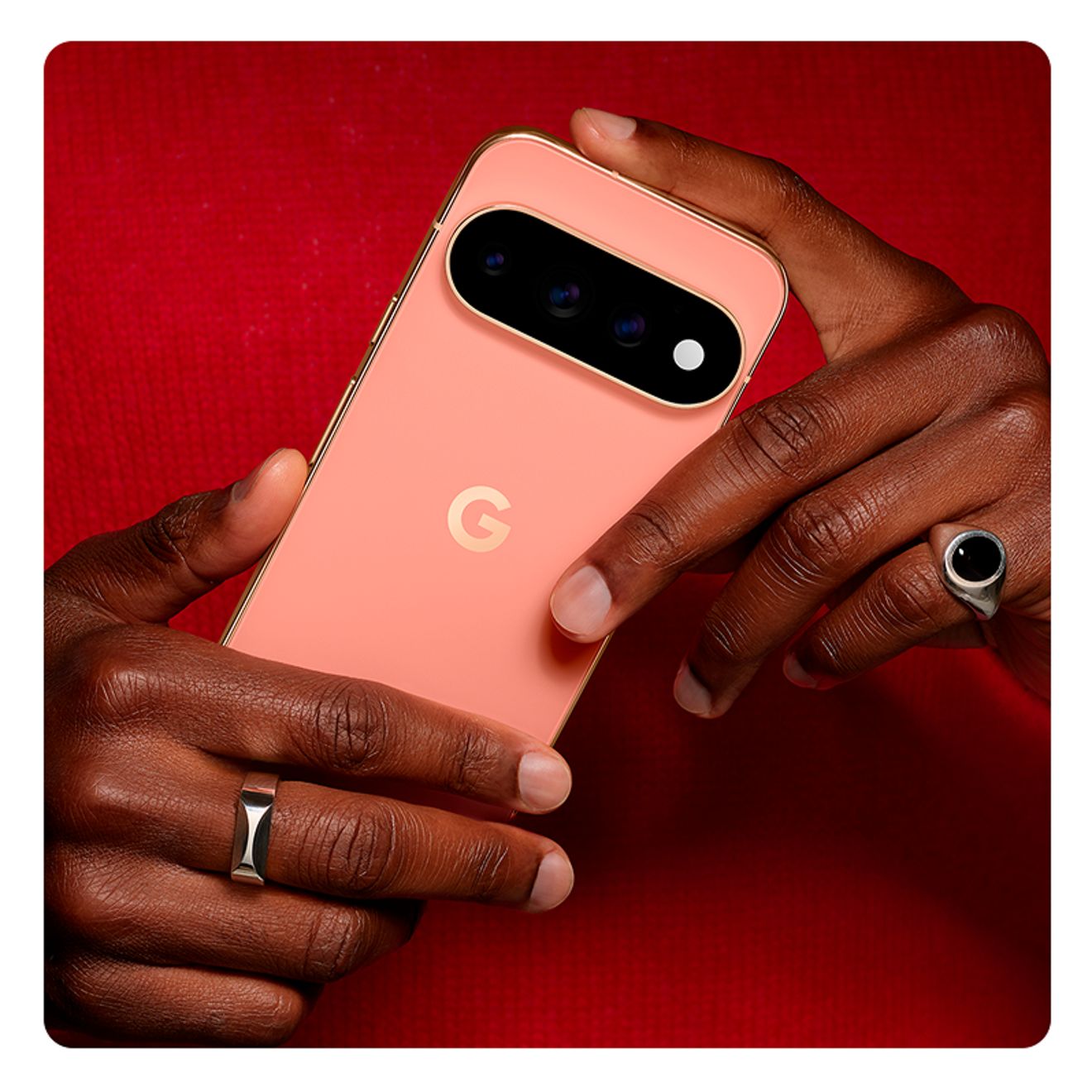 Close up of someone holding a Google Pixel 11 Pro XL phone in front of a red background 