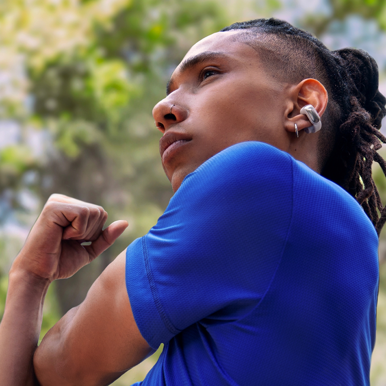 Man stretching while wearing Bose Ultra Open Earbuds.
