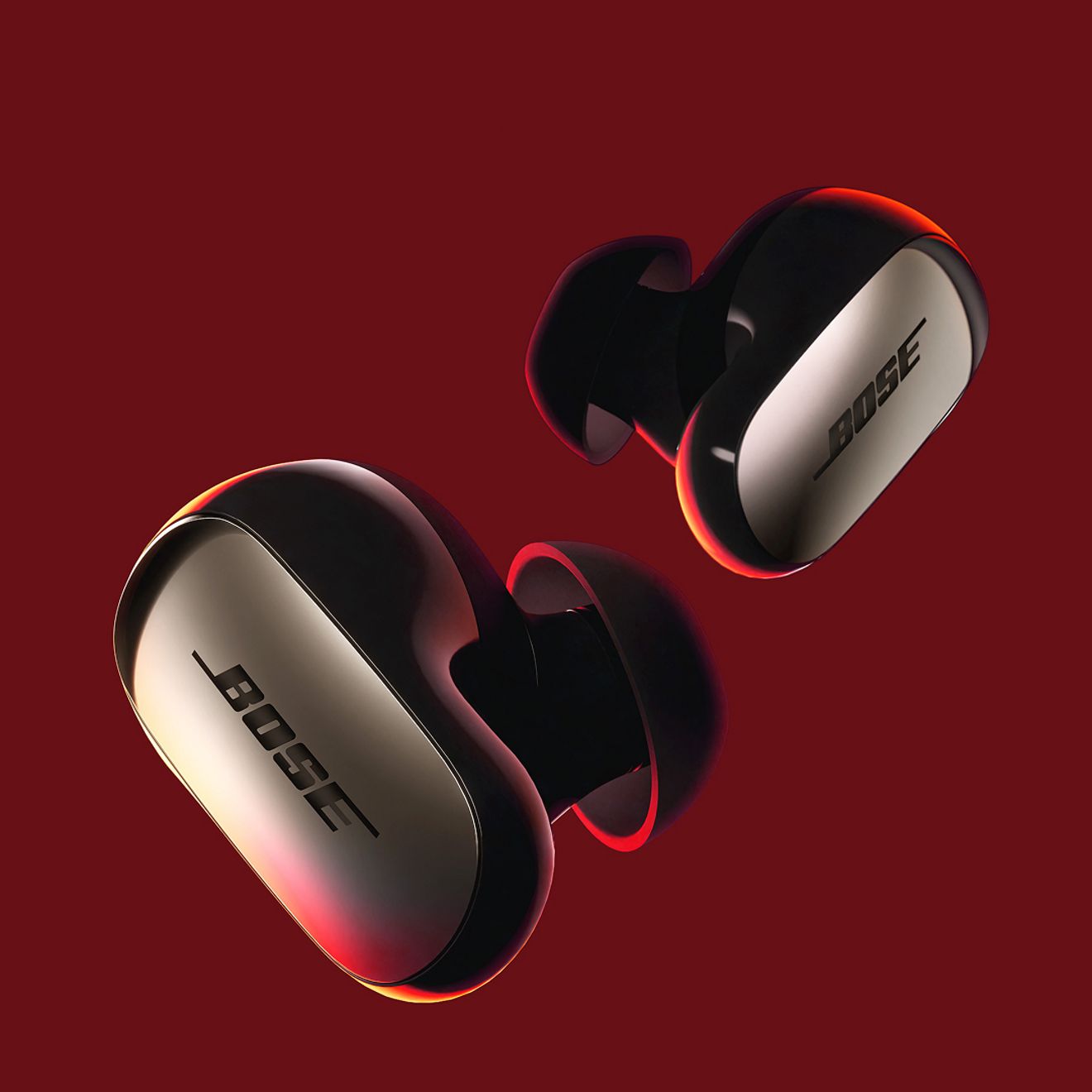 Close-up of the Bose Quiet Comfort Ultra Earbuds 2nd generation on a red background.