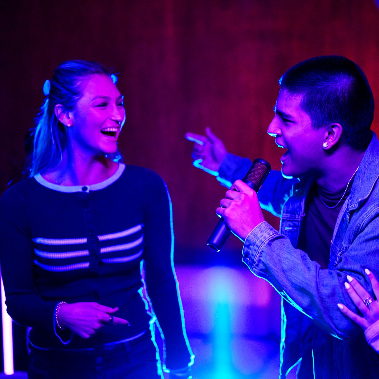 A man and a woman sing together using the JBL Easy Sing Mics 2.