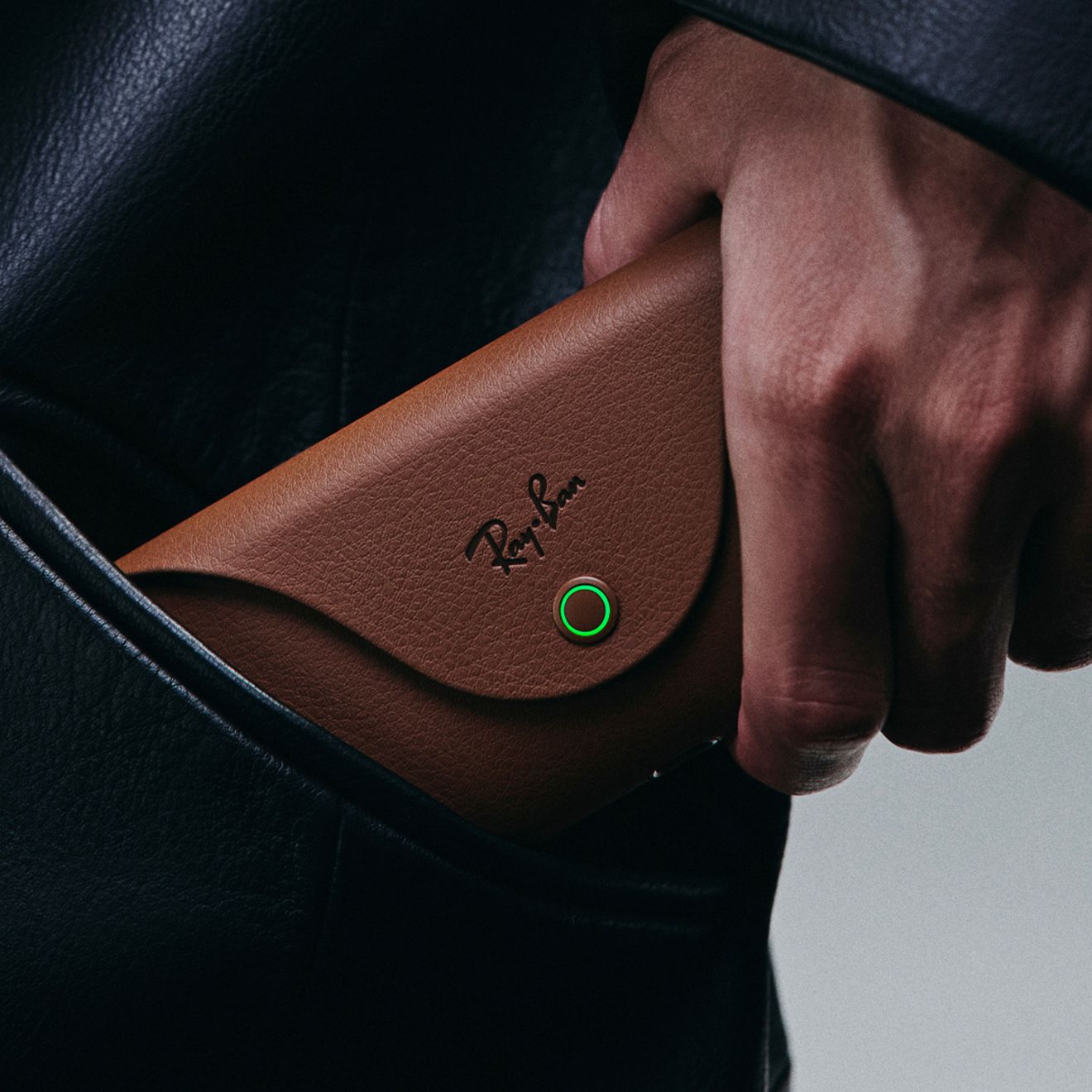 A man is putting his charging case for his Ray-Ban Meta sunglasses into his pocket.