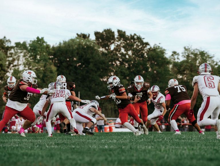 High school football players vying for the ball during a game.
