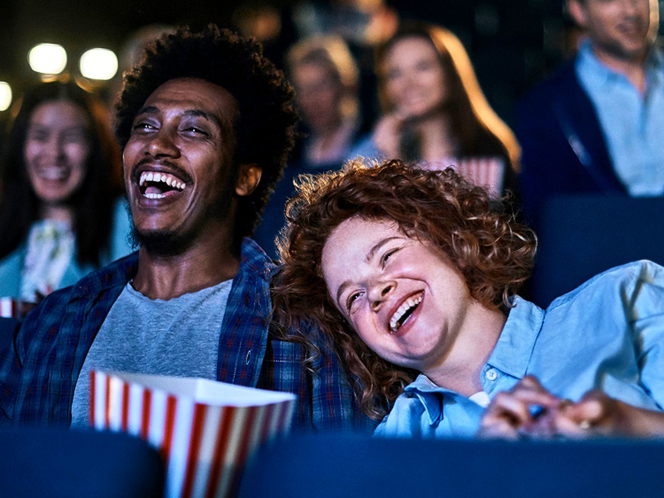 A group of people enjoy watching a movie at a theater.