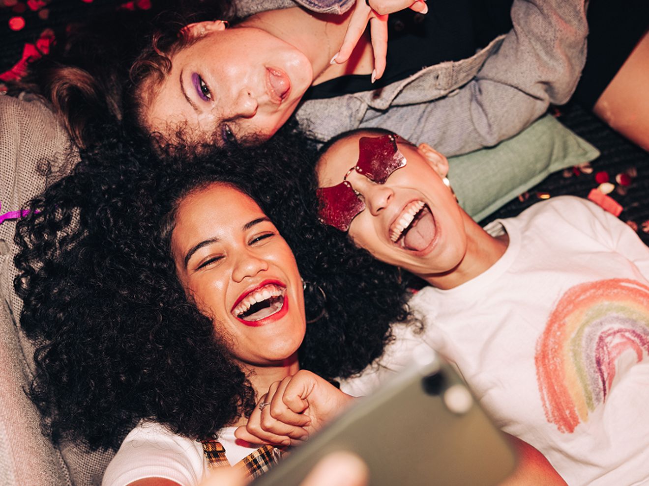 Three friends take a selfie at a party.