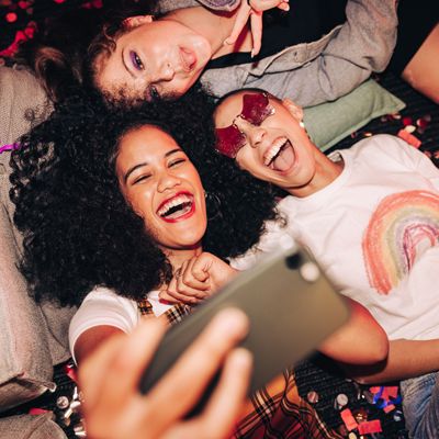 Tres amigos se toman un selfie en una fiesta.