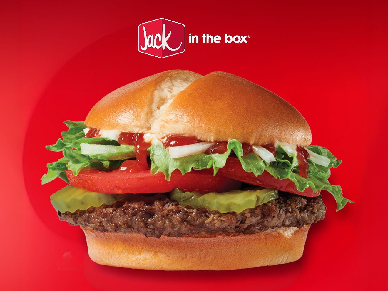 Closeup of a Jack in the Box Jumbo Jack burger on a field of red. A Jack in the Box logo hovers above the burger.