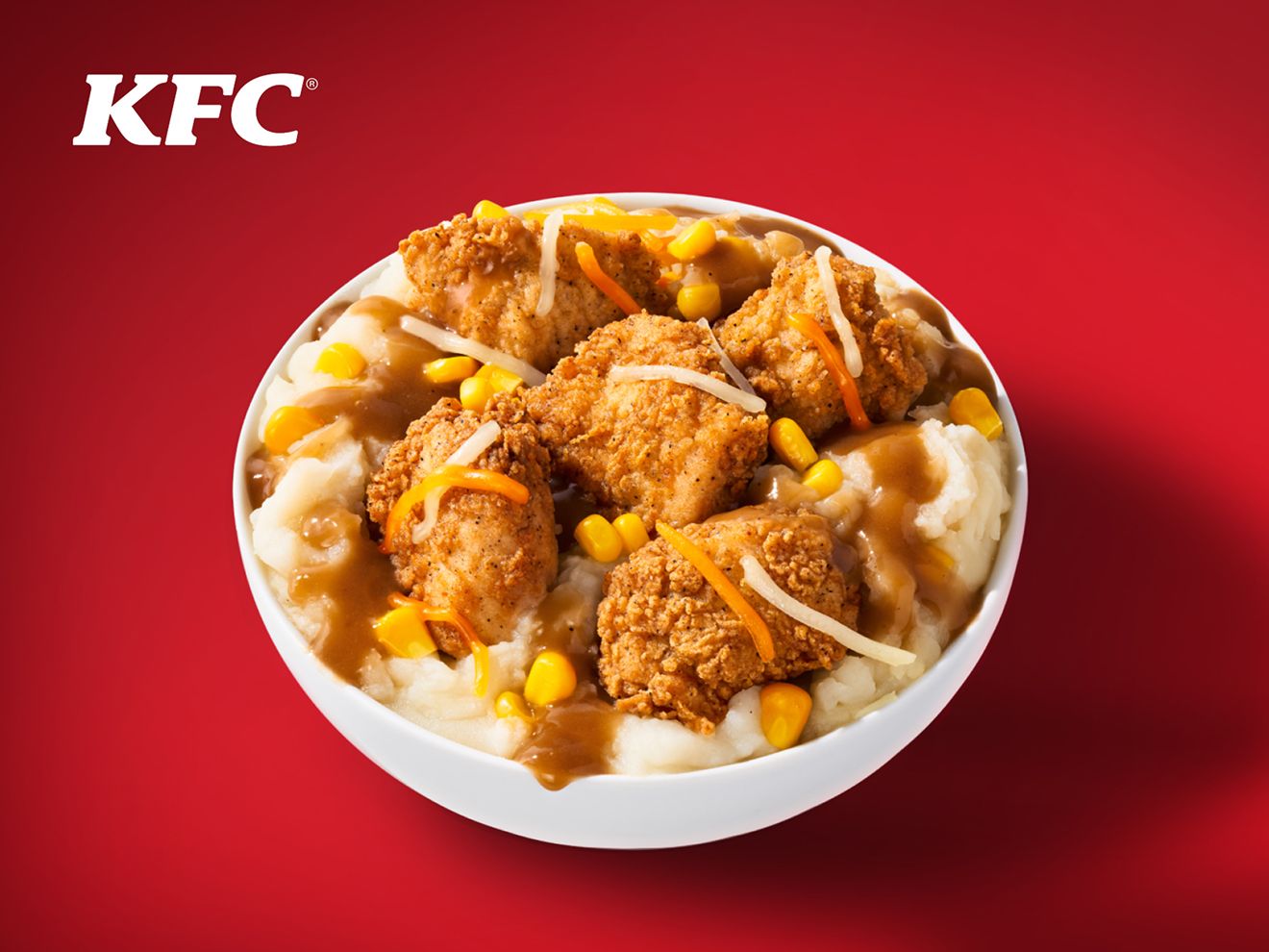 A KFC Famous Bowl resting on a red background with KFC logo in the top left corner