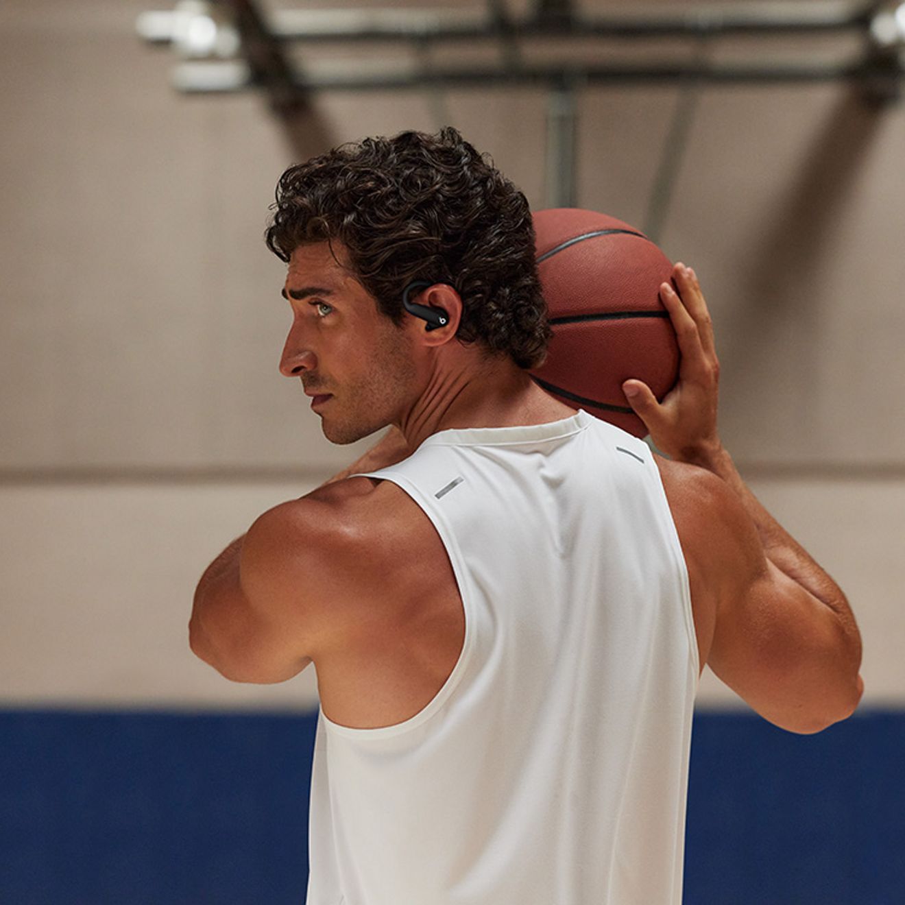 Man plays basketball while listening to music.