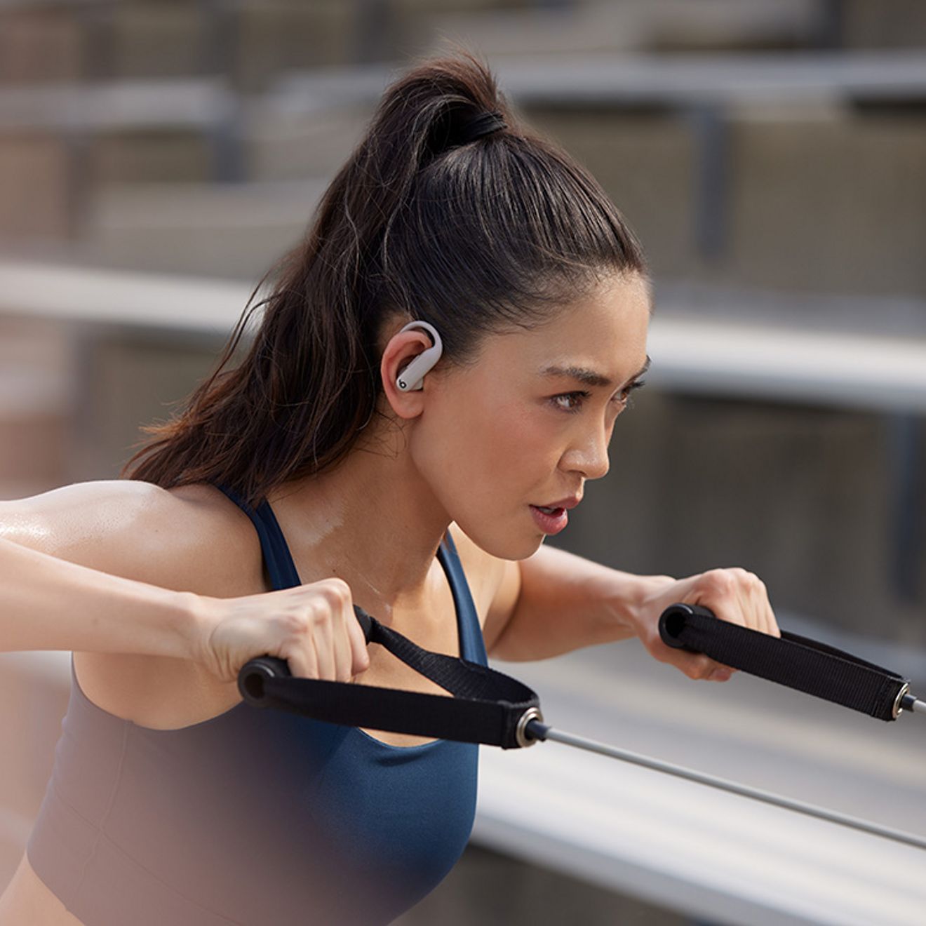 Woman uses resistance bands while listening to music.
