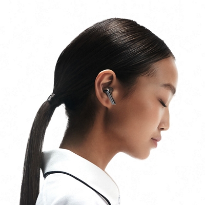 A woman wearing Galaxy Buds3 tips her head forward and closes her eyes as she listens.