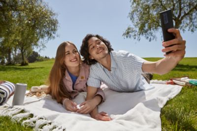 Man and woman taking selfie in a park