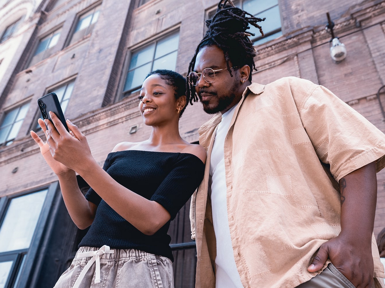 Two people look at a smartphone.