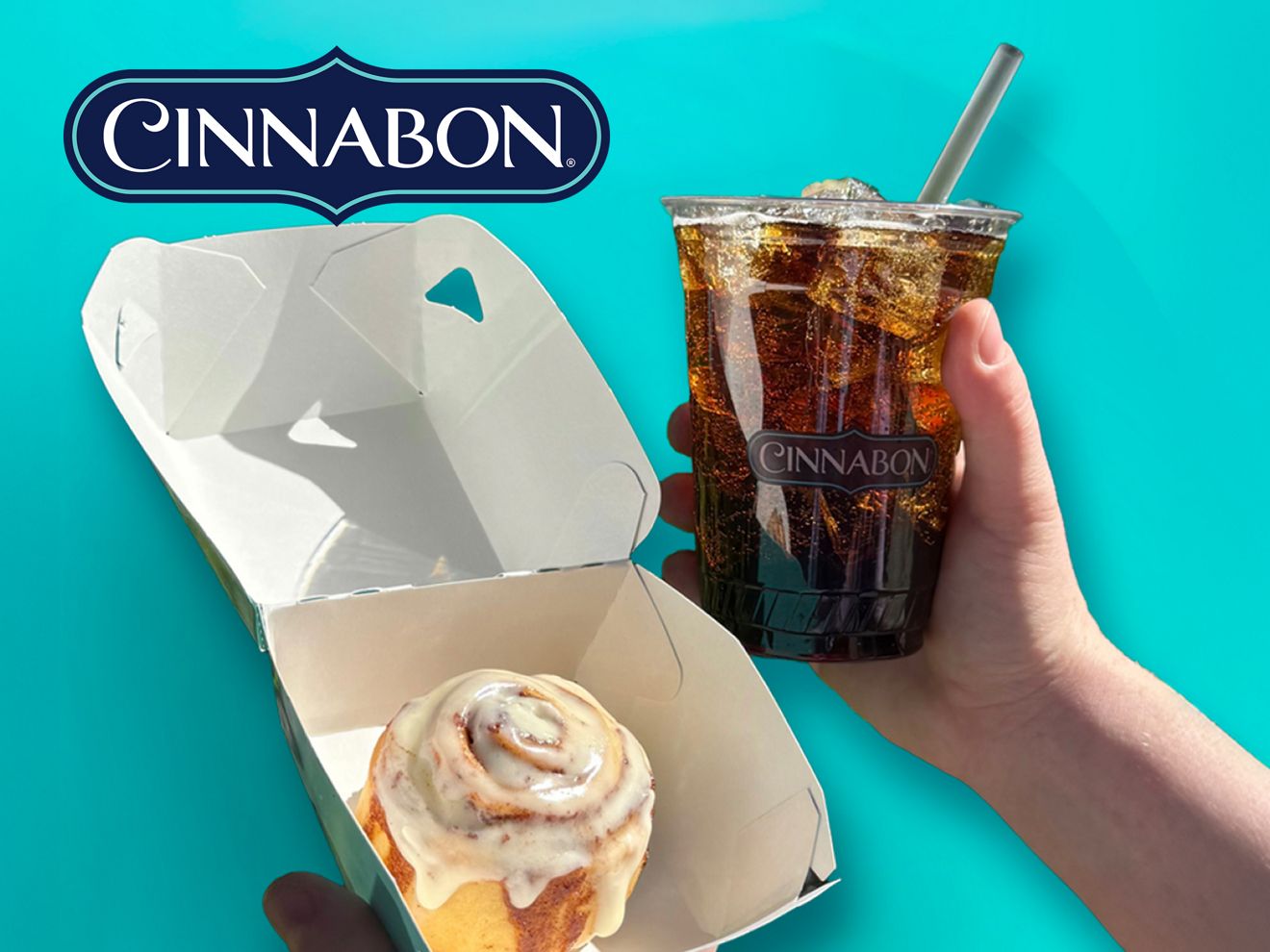 Un MiniBon de Cinnabon en una caja abierta, junto a una mano que sostiene una bebida de Cinnabon sobre un fondo turquesa brillante.