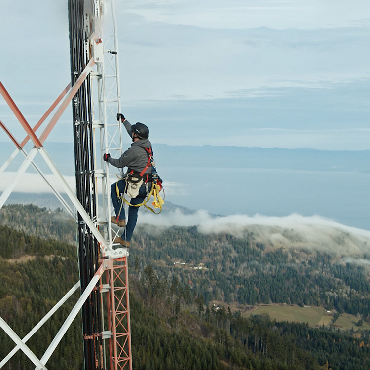 A man climbs a wireless tower.