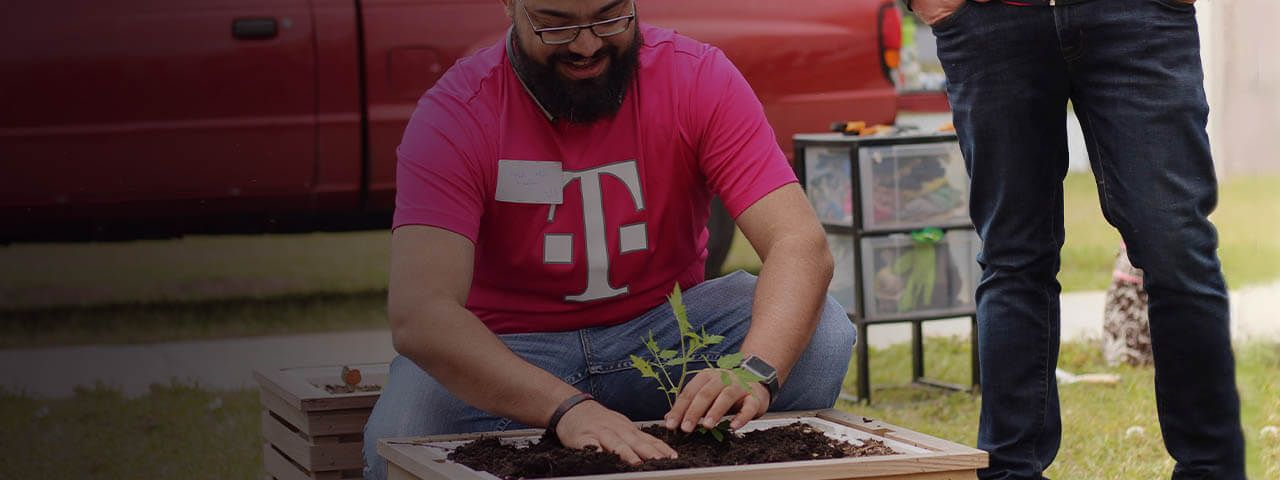 T-Mobile employee planting a garden during a volunteer event.