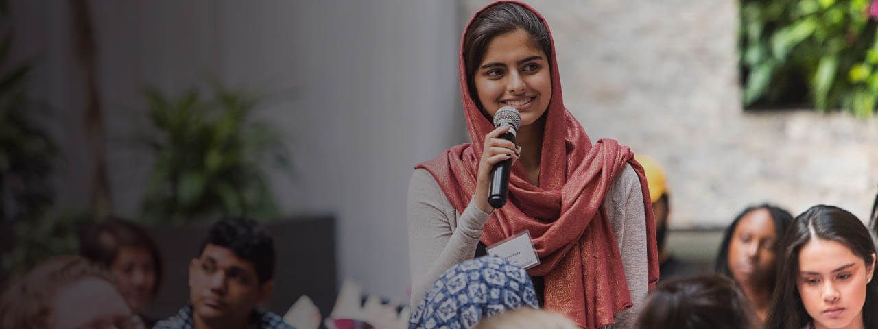Young Indian woman speaks to a group of people during changemaker challenge