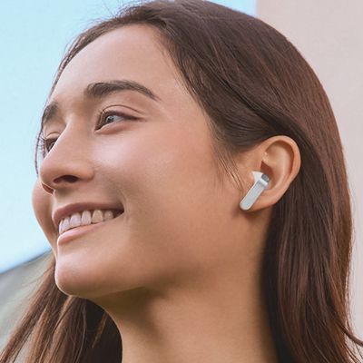 A woman is wearing Samsung Galaxy Buds four earbuds.