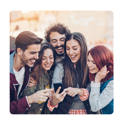 Six friends crowded around and pointing to a phone.