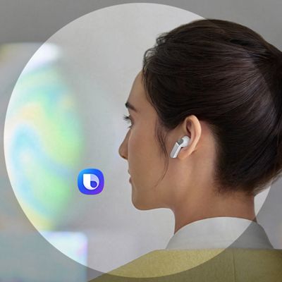 A woman smiles as she’s wearing Samsung Galaxy Buds four earbuds. An assistant-style icon appears near her with a circular overlay. 