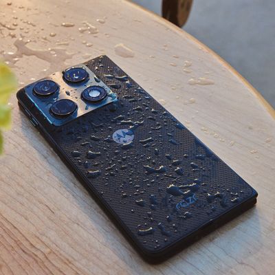 Motorola razr Fold shown from the back on a tabletop, with water droplets highlighting the textured finish and dual‑camera module.