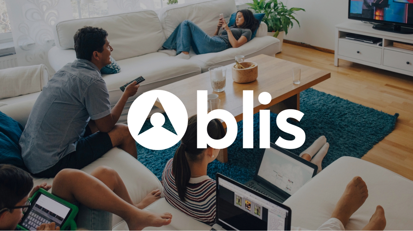 Family watching TV and using other devices in their family room.