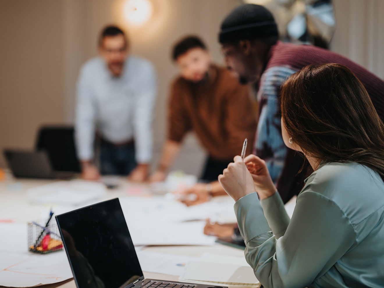 Group of business people gathered around a conference room table. 