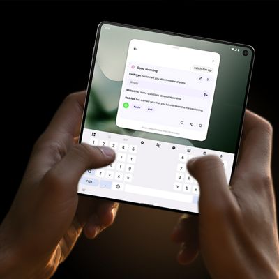 Motorola razr Fold held in landscape mode, showing a typing keyboard and notification menu across the dual displays.