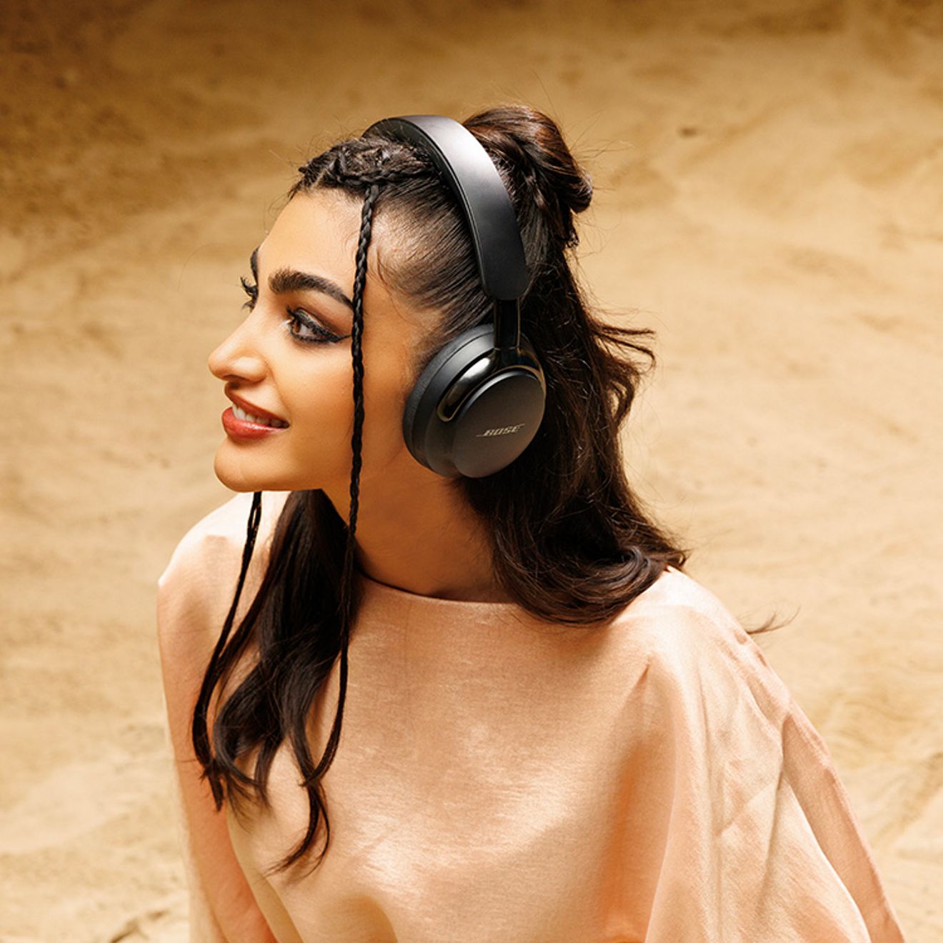 Woman contemplates as she listens to music with black headphones.