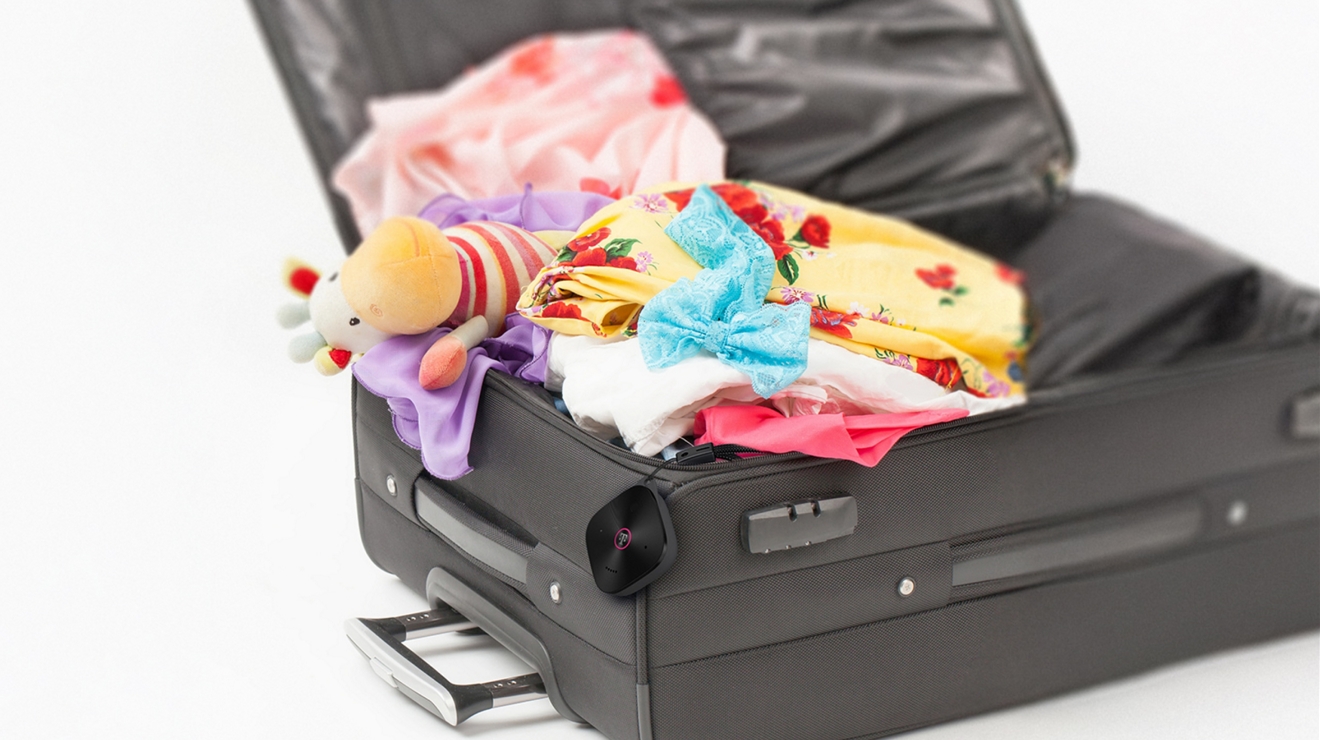Open suitcase with the SyncUP TRACKER 2 device hanging over the edge.