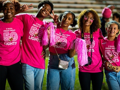A group of students wearing magenta smiles for the camera.