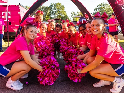 A group of students wearing magenta smiles for the camera.