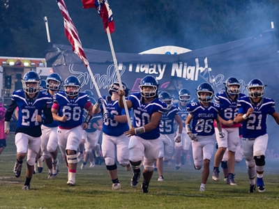 A giant inflatable Longhorn mascot is held up by several students.