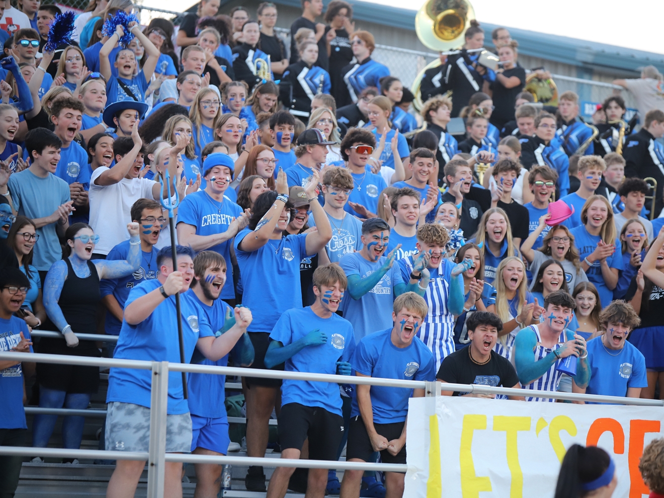 Students all decked out in blue cheer from the stands. 