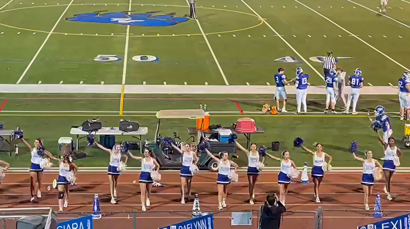 A group of cheerleaders in blue and white uniforms.