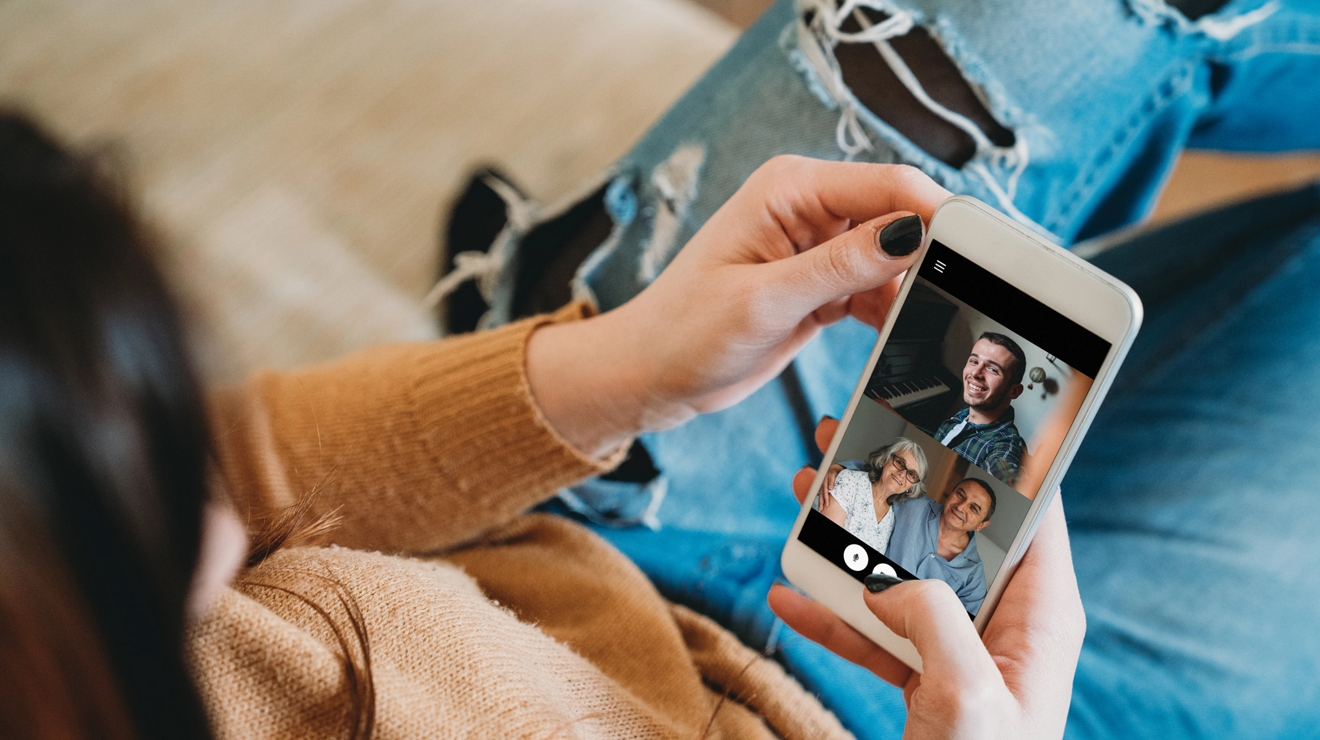 Persona hablando con otras 3 personas a través de un chat con video en un smartphone.