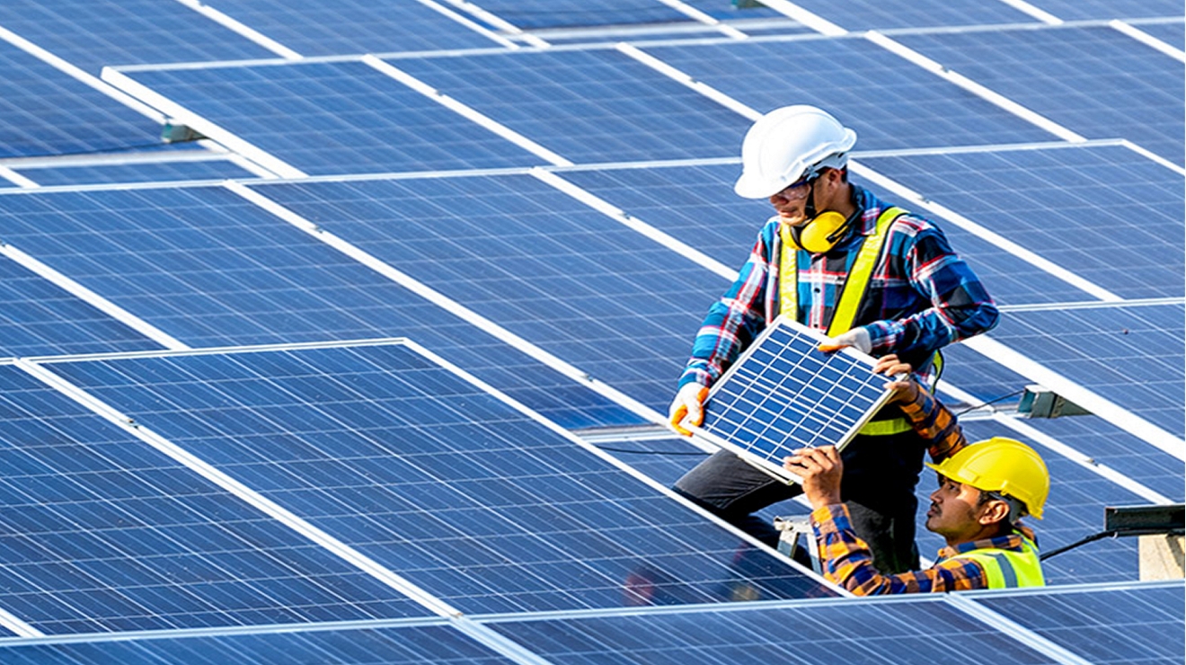 Two workers installing solar panels at a solar farm