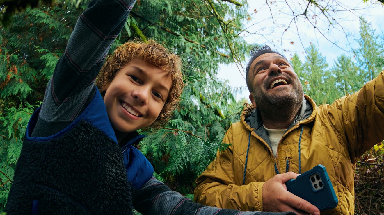 Closeup of a father and son posing for a selfie in the forest