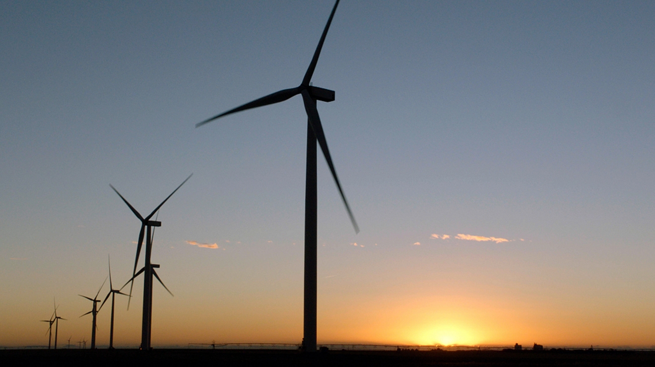 A row of wind turbines at dusk