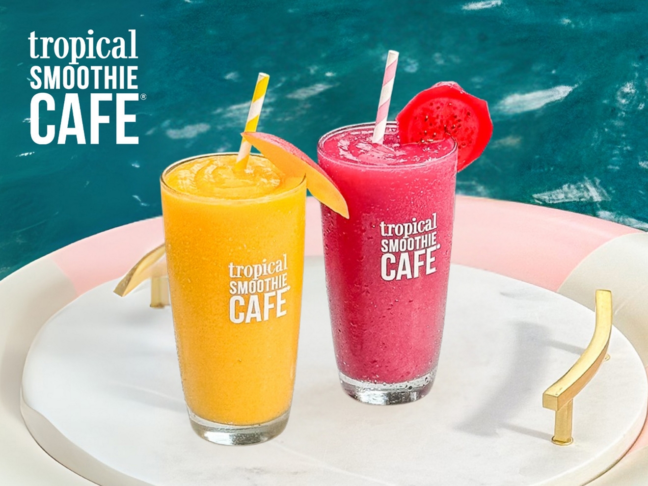 Two Tropical smoothies on a platform floating on clear blue water.