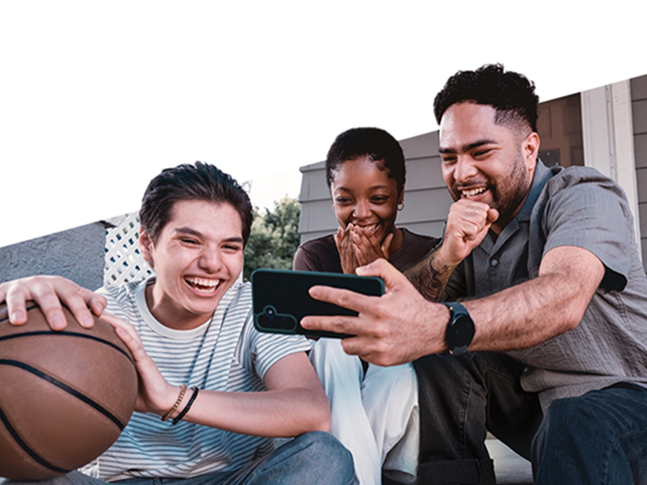 Familia mirando un teléfono y riendo juntos.​​​​​​​