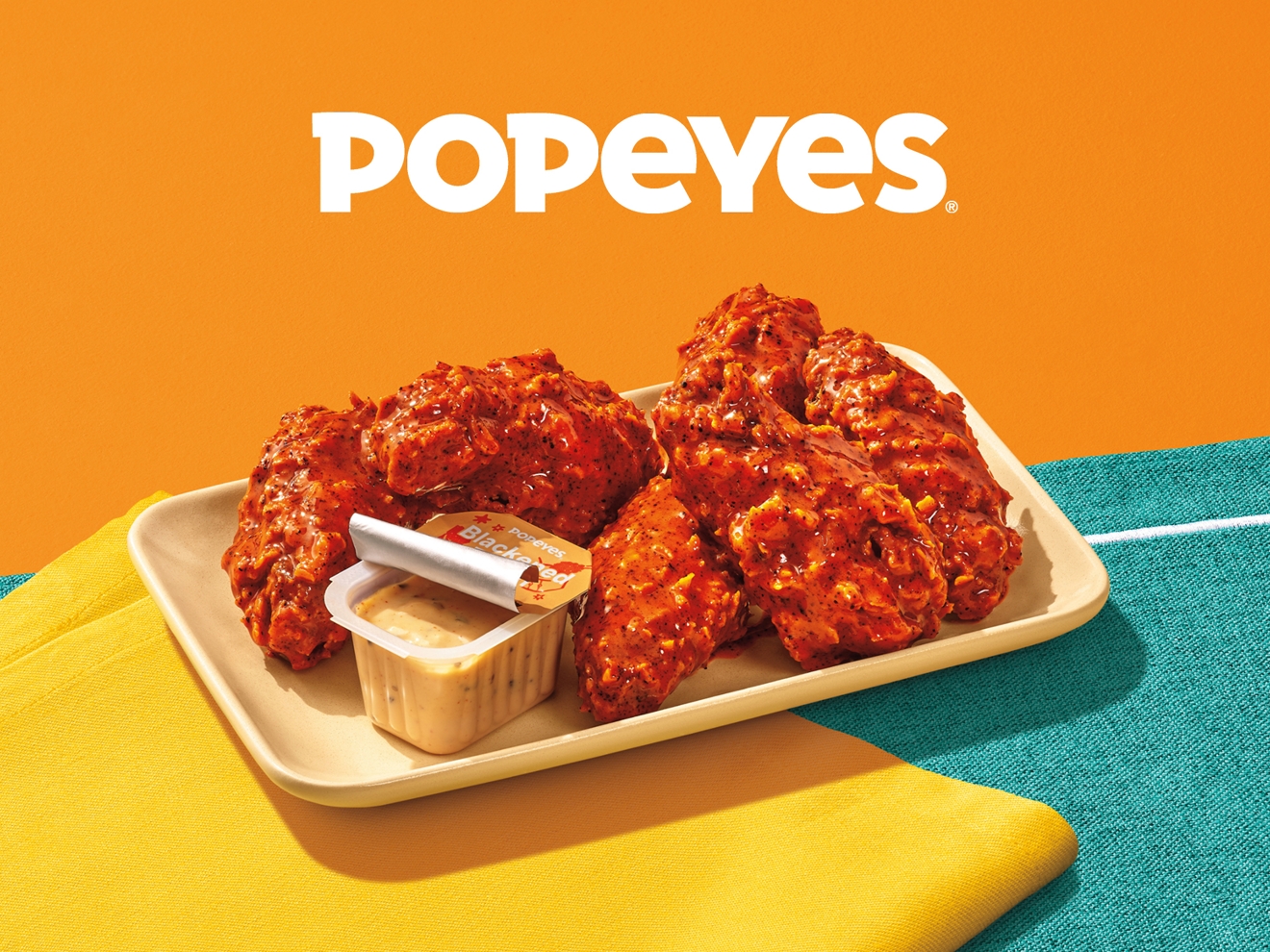 A tray of 6-piece Popeyes chicken wings and dipping sauce.