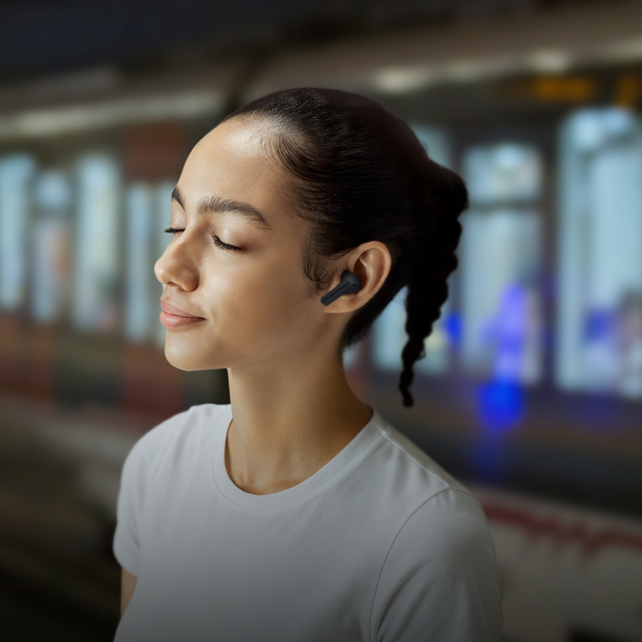 Person listening to Buds3 FE while a train passes in background
