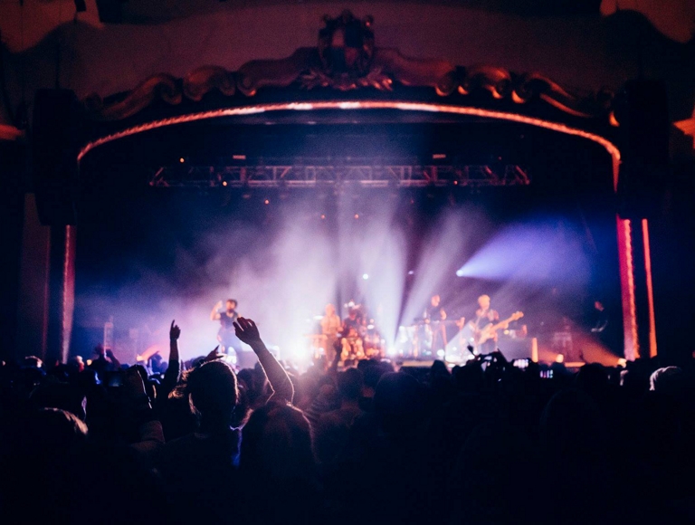 A crowd of people at a live concert capturing and sending videos via their smartphones.