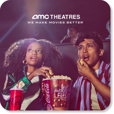 Two people eating popcorn in a movie theater.