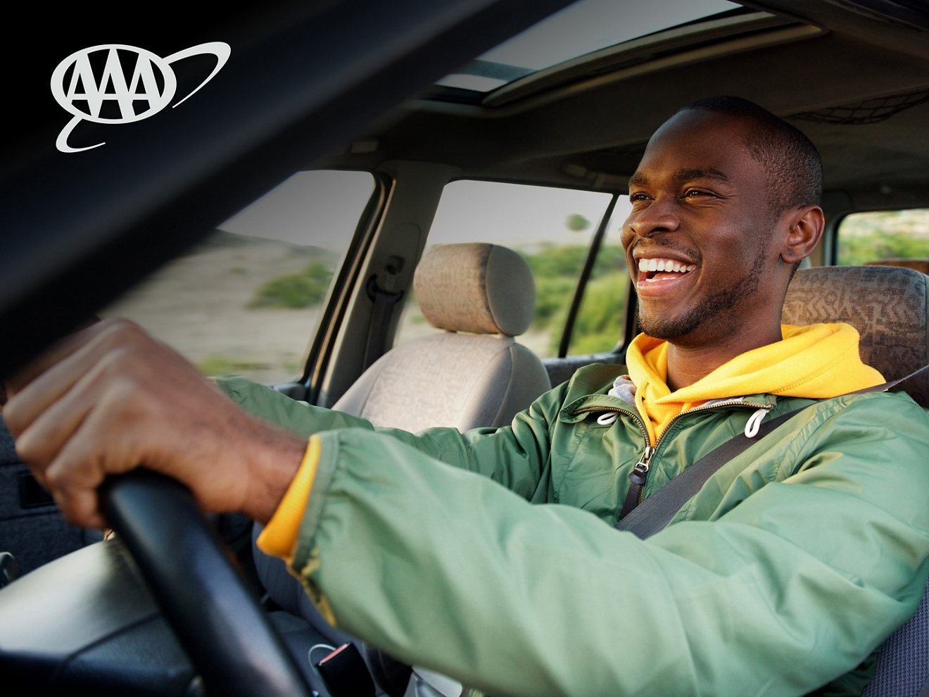 Person driving car with a big smile on their face. 