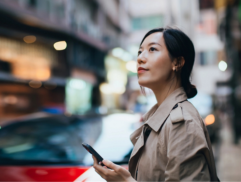 Person using a smartphone on a busy city street
