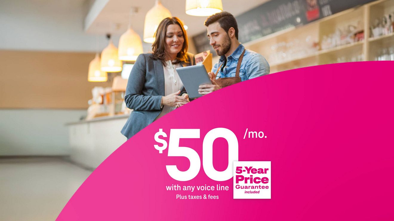 Colleagues working together around a table, using 5G Business Internet for $50 per month with eligible voice line plus taxes and fees, includes 5-year price guarantee.