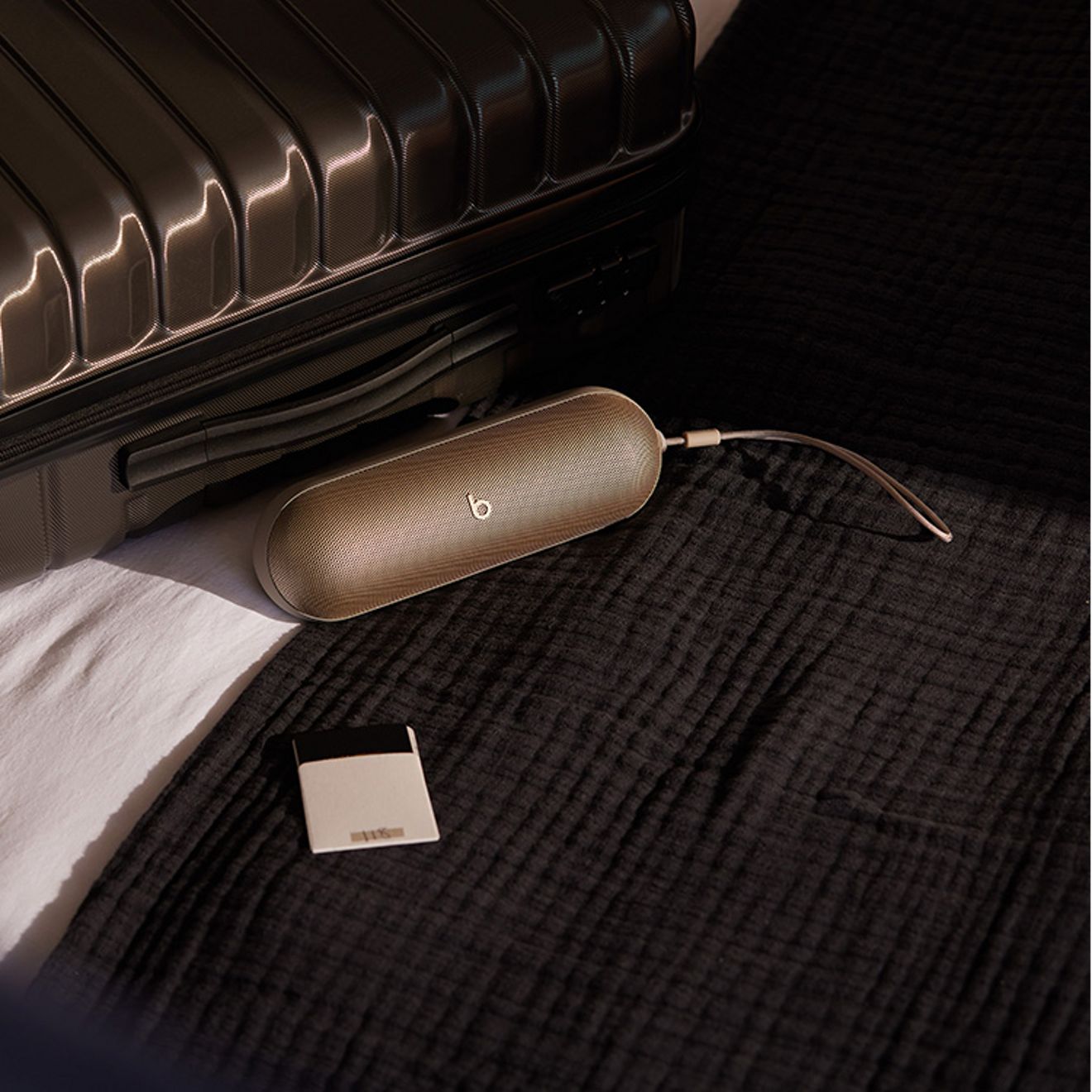 Silver beats pill rests beside suitcase.