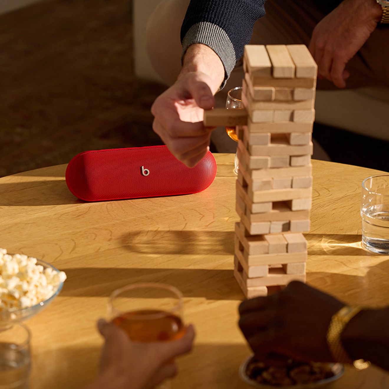 People play Jenga while a red beats pill sits in the background. 