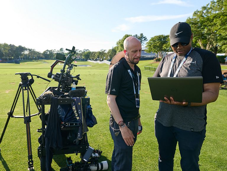 Two photojournalists configuring their equipment on the course. 